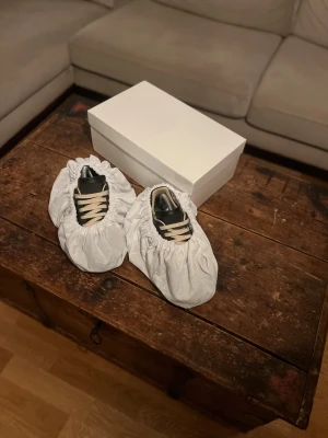 Svarta sneakers från Maison Margiela - Maison Margiela Gats skor, svart skinn och grå mocka. Är en äldre mer limiterad modell. Skorna köptes för ca 5 år sen. Skorna är i nyskick och har bara används ett fåtal gånger. Storlek 40 men passar även 41. Box och 2 dustbags ingår, kvitto finns tyvärr ej då dom köptes på vinted. Perfekta skor för dig som vill vara lite unik och inte ha skor som alla andra har! Tveka inte att skriva vid minsta fråga! ✉️🙌