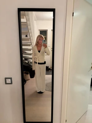 Vit omlottkofta med knytband - Superfin vit omlottkofta med knytband i midjan och långa ärmar. Koftan är stickad och har en mjuk känsla, perfekt för lager-på-lager. Snygg v-ringning och stilren look som passar till allt. Skriv för fler bilder eller frågor 💕