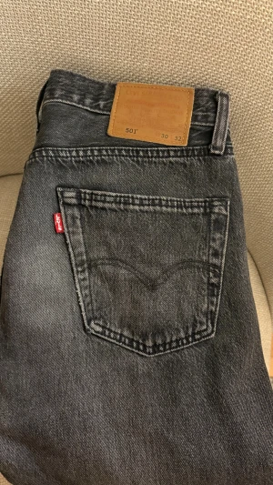 Levi's 501 svarta jeans 30/32 - Svarta Levi's 501 jeans med klassisk rak passform och fem fickor. Jeansen har en snygg tvättad look och är tillverkade i slitstarkt bomullsjeansmaterial. Bara att höra av er vid frågor eller funderingar!😊 OBS byxorna har ett litet märke efter telefonen på högra fickan. 