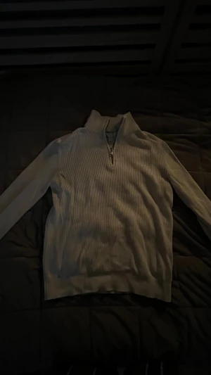 Vitt ribbad half zip tröja H&M - Snygg vitt långärmad tröja från H&M med ribbad struktur och half zip-dragkedja vid halsen. Perfekt för dig som gillar en chill och stilren look. Tröjan har en hög krage och är gjord i mjuk bomullsmix som är skön mot huden.