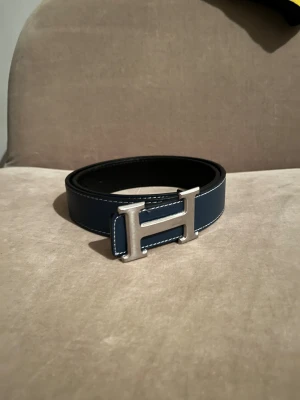 Marinblått bälte - Marinblått bälte med ett silvrigt märke