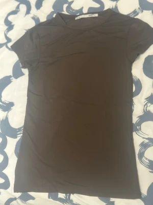 Brun kortärmad t-shirt i polyester - En enkel och stilren brun t-shirt från Lager157 med korta ärmar och rund hals. Tillverkad i mjuk polyester som känns skön mot huden. Perfekt för dig som gillar minimalistisk och clean look.