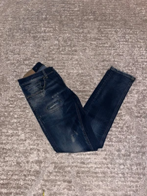 Dondup George  - Hej jag säljer ett par Dondup detox George jeans med unika slitningar i riktigt snygg marinblå färg perfekt för dig som vill ha ett par kvalitetsjeans med grym passform. Nypris ≈ 3500kr, mitt pris 1050kr.  Skick: 9/10 Storlek: W31 Midja: 40cm Lår: 23cm  Ytterlängd: 100cm Innerlängd: 77cm  Skriv gärna om du vill ha fler bilder eller har frågor!