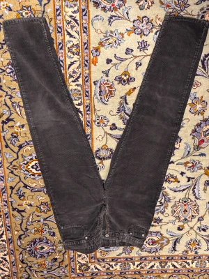 Levi's 503 svarta manchesterbyxor - Svarta manchesterbyxor från Levi's modell 503. Klassisk femficksdesign med raka ben och normal passform. Byxorna har en snygg mörk ton och är tillverkade i mjukt manchestertyg som ger en cool vintagekänsla. Perfekt för dig som gillar retrostil och streetwear.