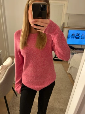 Rosa stickad tröja från Vero Moda - Mysig rosa stickad tröja från Vero Moda i storlek XS. Tröjan har rund halsringning, ribbade muddar och lång ärm. Perfekt för att addera färg till din garderob och passar dig som gillar en enkel men snygg look. Knappt använd. 
