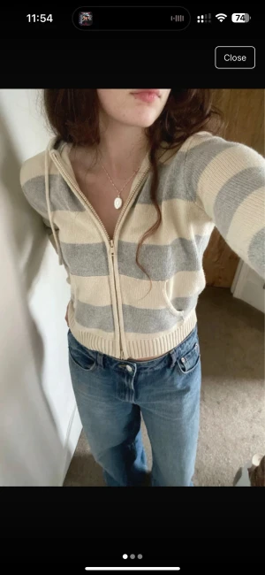 Randig hoodie från Brandy Melville - Supermysig stickad hoodie från Brandy Melville i breda grå och beige ränder. Tröjan har dragkedja framtill, huva med snörning och två fickor. Perfekt till jeans för en chill look. Finns inte i affären längre 💗 Finns inga defekter, tyget ovanför lappen tror jag bara är sydd så:)