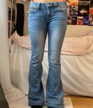 True Religion Jeans Low Rise Flare - Säljer min true religion jeans💕. Modellen på jeansen är Joey Low Rise flare i storlek W25. Jeansen har lite defekter med det inget man märker. Jeansen är uppsydda i benen så nu passar dom i mig som är 165cm lång. Jag har också haft ett band runt midjan på jeansen så att dom sitter ordentligt så det är några små hål innanför byxorna vid midjan men inget man märker. Ny pris på byxorna var 1300kr så jag säljer dom för 500kr. Fler frågor skriv till mig💕