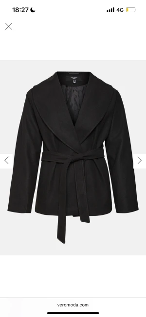 Svart kappa med bälte från Vero Moda - Stilren svart kappa från Vero Moda med bred krage och knytskärp i midjan. Jackan har en rak passform, långa ärmar och är tillverkad i ett mjukt material som ger en clean look. Perfekt för dig som gillar minimalistisk stil. Ordinariepris 750. Storlek L men passar som S 