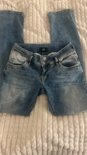 Blå jeans från LTB W28 L32 - Superrr snygga blå jeans från LTB i storlek W28 L32 med låg midja. De har klassisk femficksdesign, ljus tvätt med slitningar och silverfärgade knappar. De är använda ett fåtal gånger men det syns inte💓