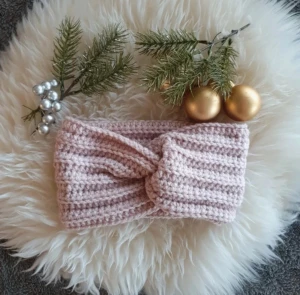 Rosa stickad pannband med twist - Virkat pannband Virkat av mig i ett mjukt akrylgarn.. Passar de ca 12 år. Onesize. Töjbart
