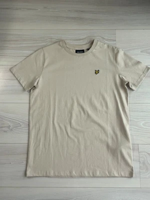 Beige t-shirt från Lyle & Scott - Snygg beige t-shirt från Lyle & Scott, ny oanvänd skick 10/10 & storlek S! Bara att höra av sig vid intresse. 
