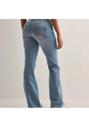 Ljusblå bootcut jeans från Nelly med rosa detaljer  - Sälja dessa blåa jeans från Nelly💕Inga defekter förutom längst ner på byxorna💞Priset kan diskuteras,skriv för fler bilder💞