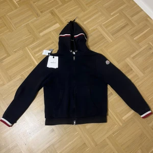Moncler Maglia zip hoodie - Säljer min stilrena zip hoodie ifrån Moncler, tröjan är i riktigt fint skick o passar alla stilar, storlek S, tags o ogs medföljer, hör av er vid minsta fundering.