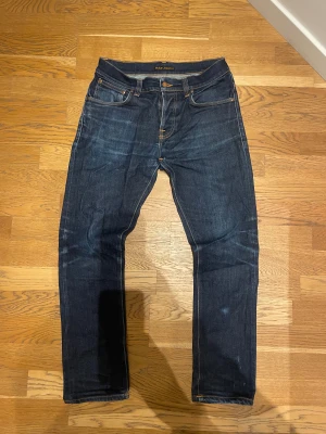 Mörkblå Nudie grim Tim  - Ett par snygga Nudie jeans med jävligt sköna fades. Dem är i passformen grim Tim i storlek 33:30. Om du har fler frågor hör av er
