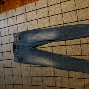 Blå jeans från Jacob Cohen - Snygga blå jeans från Jacob Cohen med klassisk femficksdesign och guldfärgad patch bak i midjan. Jeansen har raka ben och subtila slitningar framtill för en cool look. Perfekta för dig som gillar stilrena och bekväma jeans med exklusiv känsla. Tar även byten och pris kan diskuteras 