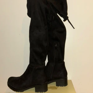 Svarta mockastövlar med snörning - Snygga svarta stövlar i mocka med hög klack. Stövlarna har rund tå, dragkedja på sidan och snörning upptill för att justera passformen. Perfekta för höst och vinter, tänk Ariana Grande vibes old era.👢🖤                      ✨63 cm från marken                                            ✨58 från sulan                                                        ✨5 cm hög klack