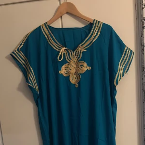 Gandoura  - Marockansk gandoura klänning. Väldigt snygg färg. Kan användas till vilken storlek som helst. Klipp längst ner på klänningen om den är lång för dig. Köpt från Casablanca i Marocko. Helt oanvänd!