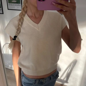 Beige stickad topp med v-ringning - Säljer en jättefin beige stickad topp med v-ringning och korta ärmar och som har en ribbad kant nedtill. 💗