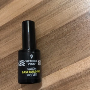 Victoria Vynn Base Build Gel 15ml - Victoria Vynn Salon Base Build Gel för UV/LED-lampa. Kommer i en svart flaska på 15 ml med tydlig etikett. Perfekt för att bygga och stärka naglar, används som bas vid gelmanikyr. Professionell kvalitet, lätt att applicera.