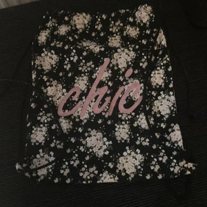 Blommig svart gympåse - Svart ryggsäck i gympåse-modell med blommigt mönster. Säljer pga har ej användning för den.