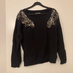 Collegetröja  - Svart collegetröja från soaked in luxury i storlek S med paljetter 