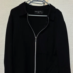 Daniel De Prato tröja - Svart kofta från Daniel De Prato med hel dragkedja framtill och klassisk krage. Långärmad och enkel design som passar perfekt till lager-på-lager. Snygg och stilren, lätt att matcha med allt. Slimfit och nästan i nyskick knappt använd.