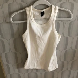 Vit ribbad linnetopp  - Säljer en vit ribbad linne . linnet har tajt passform. Den är S men passa S-L den är mycket stretch i. 
