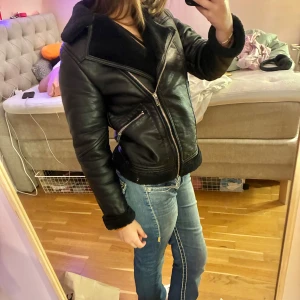 Svart croppad Shearling skinnjacka med silver dragkedjor - Varm och perfekt för vintern och hösten! Storleken står inte men upplever den som S och säljer pga den inte kommer till användning men nyligen köpt Jackan har två sneda fickor med dragkedja, teddyfoder på insidan och vid ärmslut 🖤❄️