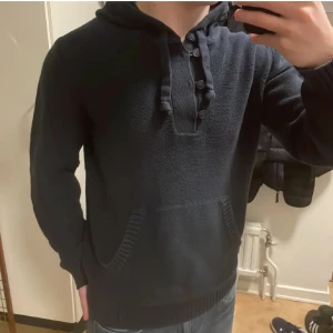 Blå unik stickad hoodie - Riktigt fet stickad blå hoodie med knappar. Perfekt till kallare väder. Modellen är 180cm, 73kg. Priset går att diskutera!