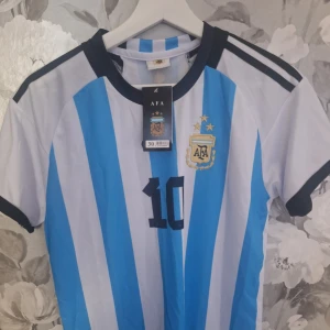 Argentina Messi #10 fotbollströja+Shorts  - Säljer en officiell Argentina fotbollströja med Messi och nummer 10 på ryggen + Shortsen till tröjan. Båda är aldrig annvända och har prislappen kvar! PRIS GÅR SÅKLART ATT DISKUTERA ☺️