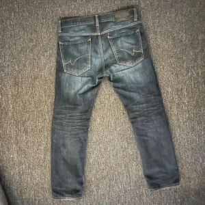 Crocker Jeans - Mörkblå jeans från Crocker, lite slitet på fronten visas på bilden, men inget som påverkar byxorna. Med storleken 33/34.