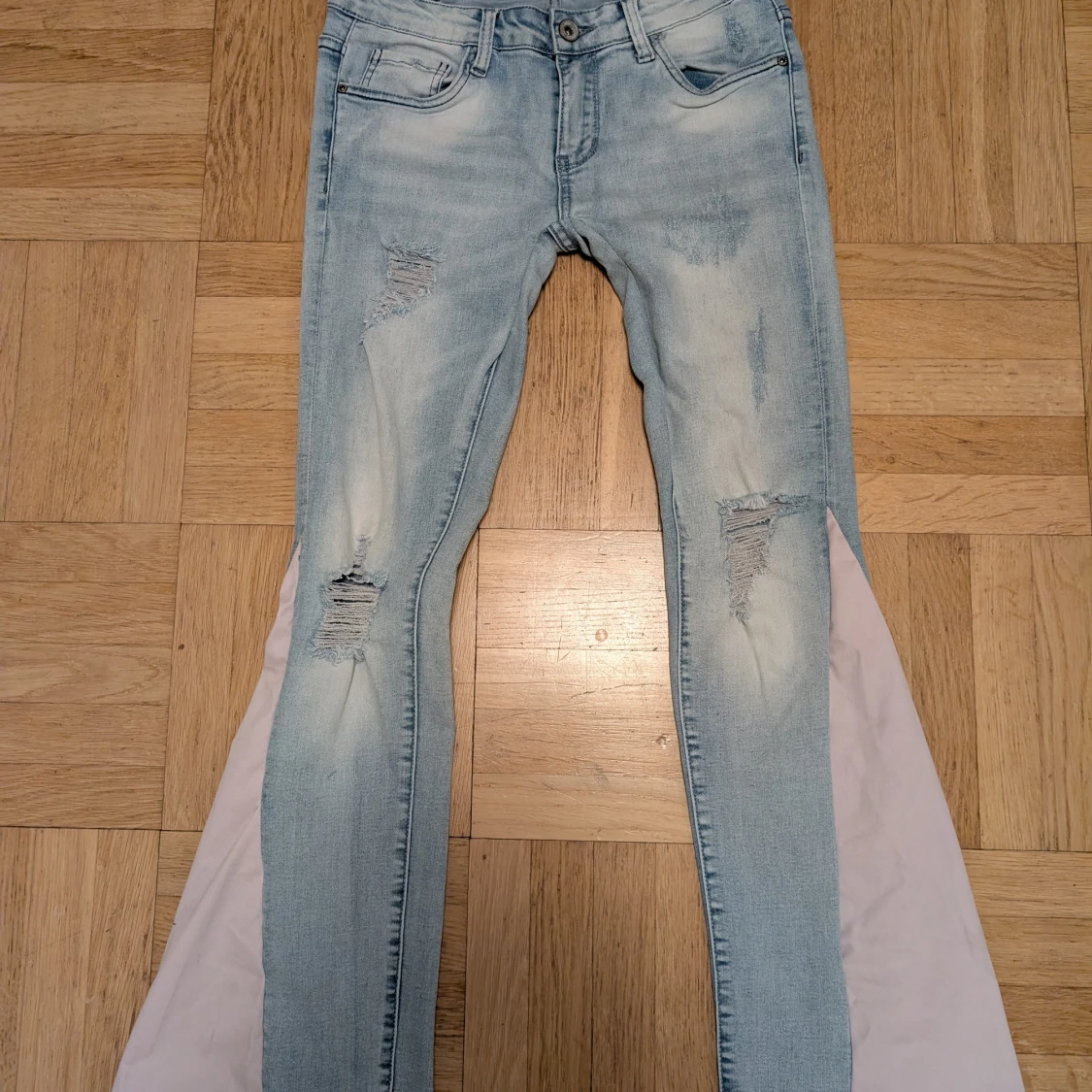 Ljusblå bootcut jeans med slitningar