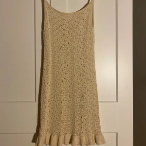 Beige spetsklänning från H&M - Supersöt beige klänning från H&M med spetsmönster och volangkant nertill. Ärmlös modell med smala axelband och en mjuk känsla. Perfekt för sommarens alla tillfällen och enkel att styla med sneakers eller sandaler.