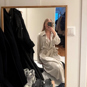 Beige linne trenchcoat från Weekday - Säljer en beige linne trenchcoat från Weekday, modell Julie Linen Mix Trench. Den har klassisk krage, knappar framtill och ett matchande bälte i midjan. Tillverkad i linneblandning med långa ärmar och snygg omlott-look. Perfekt för dig som gillar stilrena och tidlösa plagg. Aldrig använd med lappen kvar. Nypris 1250kr. 