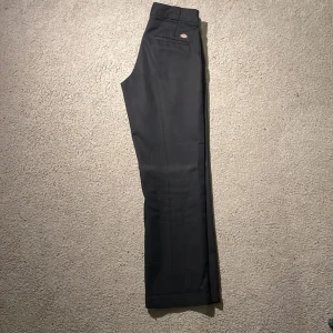 Svarta Dickies 874 straight pants W31/L32 - Svarta Dickies 874 byxor med klassisk straight passform och normal midja. Byxorna har en stilren look med fickor bak och fram, och är tillverkade i slitstark polyesterblandning. Perfekta för dig som gillar streetwear och enkel stil. Använda endast fåtal gånger. Säljes i Falun/Stockholm