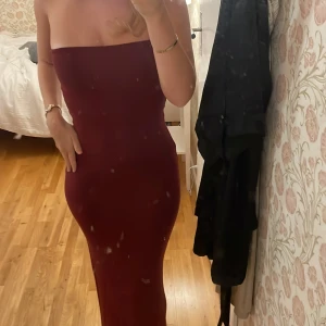 Vinröd axelbandslös långklänning - Säljer en vinröd, tight långklänning utan band. Klänningen är från Gina och är i ett väldigt bra skick. Perfekt till middagar😘