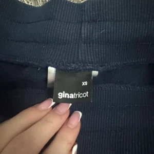 Mörkblå mjukisbyxor från Gina Tricot XS - Mörkblå mjukisbyxor från Gina Tricot i storlek XS. Byxorna har bred resår i midjan med snörning och raka, vida ben. Perfekta för en chill och avslappnad stil. Tillverkade i mjukt material för extra komfort.