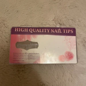 High Quality Nail Tips från Beshyne - Säljer ett set med High Quality Nail Tips från Beshyne. Nageltipparna är tekniskt tunna och anpassade för att ge en snygg och naturlig look. Kommer i en genomskinlig plastförpackning med rosa och lila detaljer på locket.