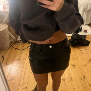 Kort skinnkjol  - Kort jeanskjol, går att ha både låg och högmidjad. Helt oanvänd 