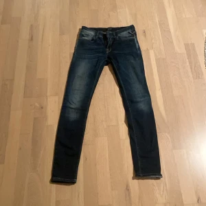 Mörkblå Replay skinny jeans w27 L30 - Snygga mörkblå jeans från Replay med skinny fit och klassiska femficksdetaljer. Jeansen har ljusa slitningar framtill och bakfickor med dekorativa sömmar. Perfekta för dig som gillar en smal siluett och stilren look.