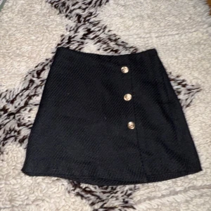 Svart fin klassisk kjol - Fin svart klassisk kjol med guld knappar. Bra skick och i storlek: xs