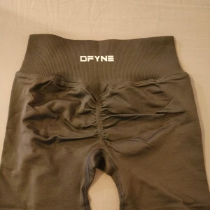 Grå träningsshorts från DFYNE - Grå träningsshorts från DFYNE med scrunch-detalj bak. Tillverkade i stretchigt material med 90% polyamid och 10% elastan för en tight och bekväm passform. Perfekta för träning eller chill dagar.