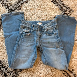 Ljusblå bootcut jeans med fickdetalj - Snygga ljusblå low waist jeans från gina Young. De är i storlek 152. Har några små färgfläckar som inte går bort men annars är de i bra skick