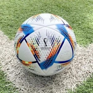 Adidas VM 2022 Al Rihla fotboll - Säljer en officiell Adidas Al Rihla fotboll från VM 2022 i Qatar. Bollen är vit med färgstarka detaljer i blått, rött, orange och gult samt svarta inslag. Tillverkad i syntetmaterial med texturerad yta och modern grafik. Perfekt för matcher och träning.