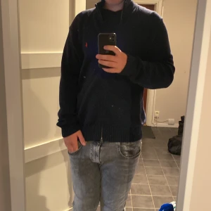 Mörkblå stickad kofta från Polo Ralph Lauren - En stilren och snygg mörkblå stickad kofta från Ralph lauren. Passar bra till både storlek L och XL. Tröjan är lite för stor för mig på ca 185cm 83kg. Frågor och funderingar är bara att höra av sig👍