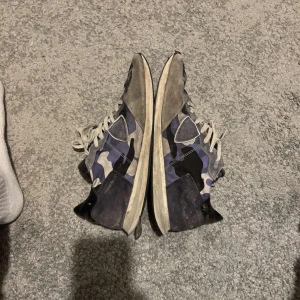Philippe modell - Snygga sneakers från Philippe model med blått, svart och grått camouflagemönster. Skorna har detaljer i mocka och skinn, vita snören och svart häl. Några skavanker men modellen säljs inte längre och funkar bra. Pris kan diskuteras vid snabb affär.