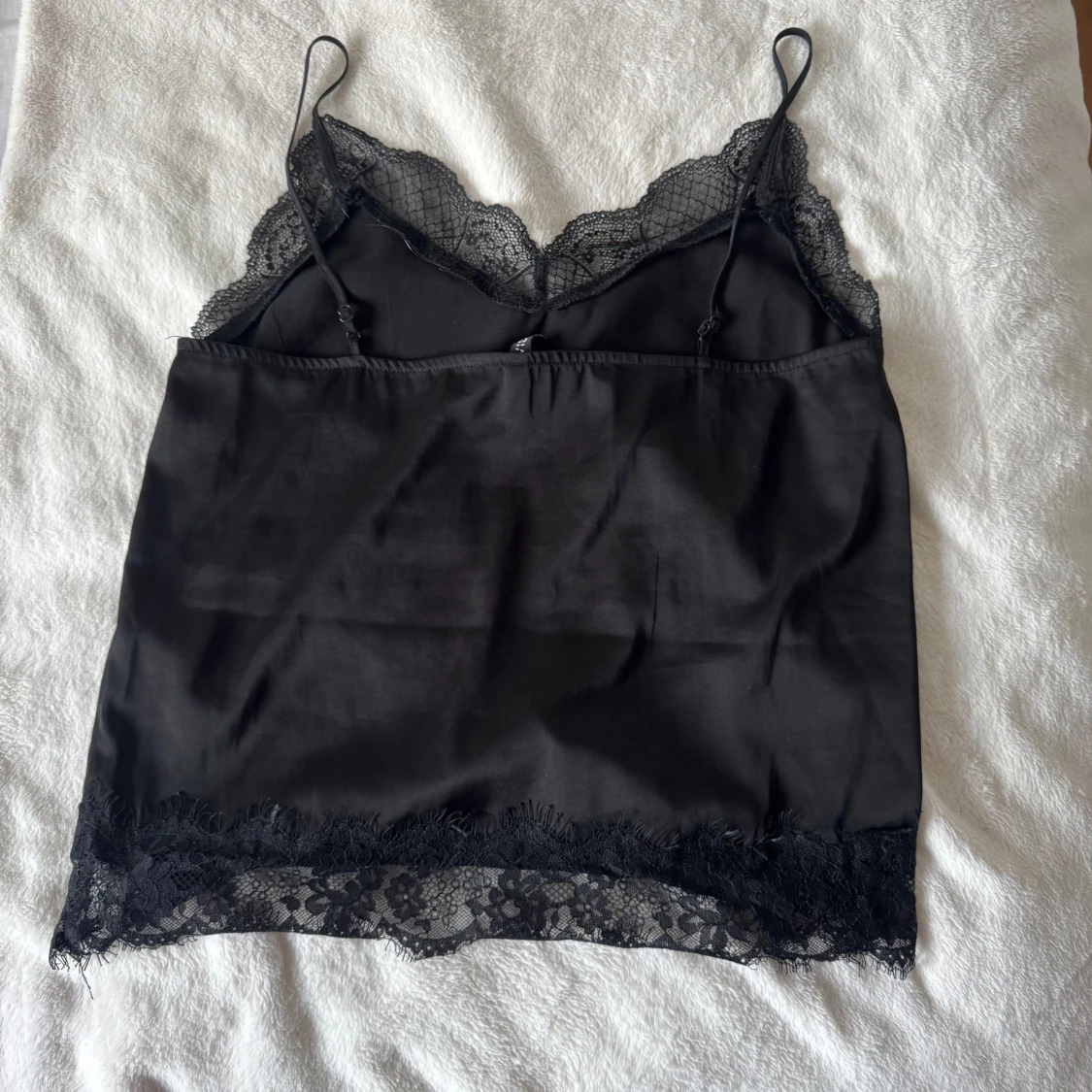 Svart linnetopp med spetsdetaljer