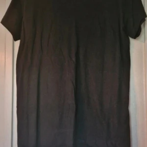 Svart t-shirt med tryck 'Hate You 2' - Svart t-shirt med trycket 'Hate You 2' på ryggen. T-shirten har klassisk passform och korta ärmar. Materialet känns som bomull och trycket har en lite sprickor. Storleksmässigt skulle jag snarare säga att det är en M än en L som den är märkt som.