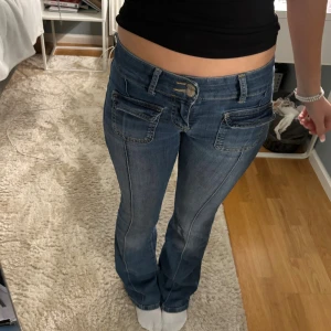 Blå bootcut jeans från Nelly - Snygga blå jeans från Nelly med bootcut och låg midja.💗 Jeansen har markerade sömmar där fram och stora fickor framtill med vikfickor. Lite slitna längst ner men inget man märker💗💗