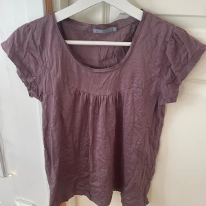 Lila topp - Lila volangtopp med urringning ifrån Åhléns, stl S.